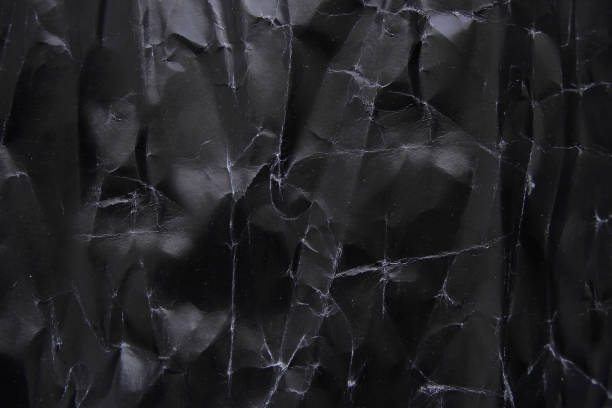 istock Crumpled sheet of black paper full frame use as background for text 1224197379