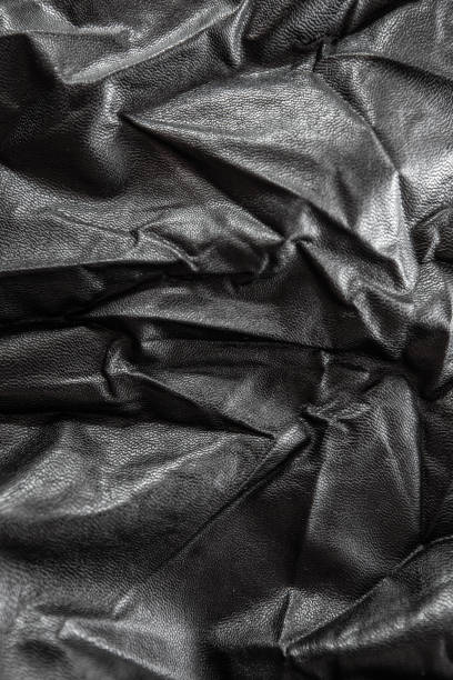 istock crumpled fabric leather, black with a silk tint, closeup texture 1224198672