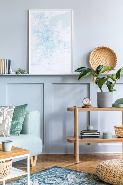 istock Stylish interior of living room with mock up poster frame, design sofa, coffee table, console, plant, carpet, pillows, plaid, books, clock and elegant personal accessories in modern home decor. 1224199451