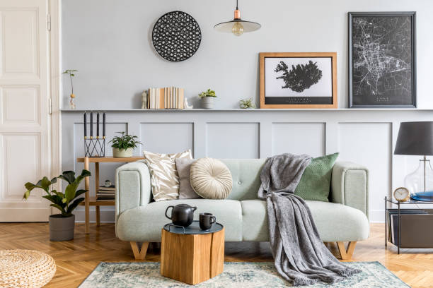 istock Stylish interior design of living room with modern mint sofa, wooden console, cube, coffee table, lamp, plant, mock up poster frame, pillows, plaid, decoration and elegant accessories in home decor. 1224199544