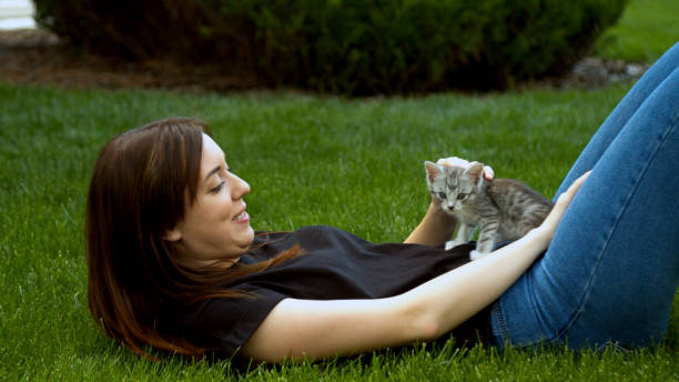 istock Woman stroking kitten in garden 1224200743