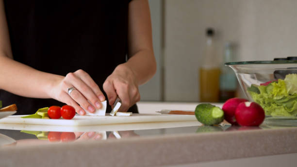 istock Woman cutting cheese in kitchen 1224200758