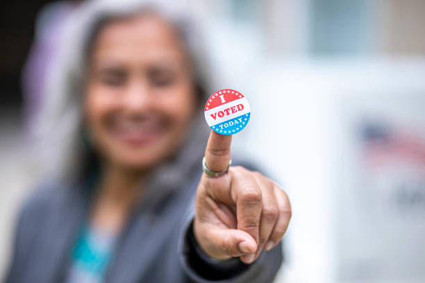 Senior Mexican Woman with I Voted Sticker A beautiful senior mexican woman at the voting booth voting rights stock pictures, royalty-free photos & images