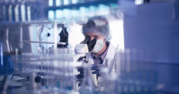 istock Young female microbiologist studying coronavirus - protective workwear 1224202373