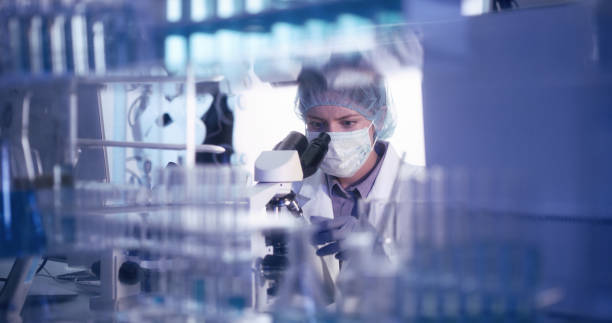 istock Young female microbiologist studying coronavirus - protective workwear 1224202376