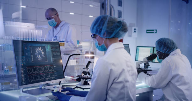 istock COVID-19 - laboratory team working on coronavirus vaccine. Protective workwear 1224202709