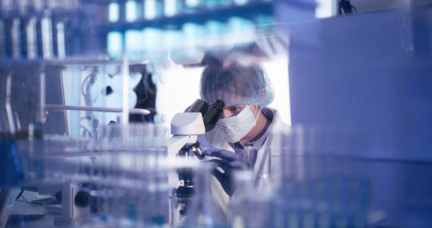 istock Young female microbiologist studying coronavirus - protective workwear 1224202960