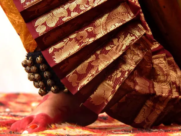 Balance of a dancer. Dance Form Indian Classical Feet, Dancer Performing On A Stage With Maroon Coloured Dress with ghungru (ghnughroo) in her feets