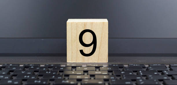 istock One wooden cube on a keyboard with the inscription nine. 1224204363