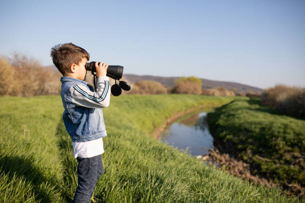 istock A young boy in the countryside looking through binoculars 1224205706