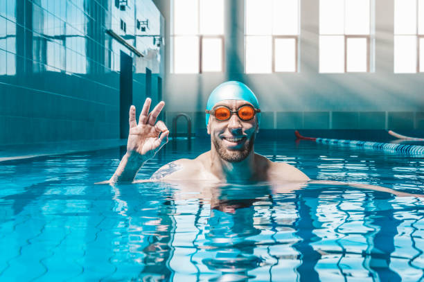Portrait of a man in the pool. He is wearing huge funny glasses. Water sports concept. stock photo