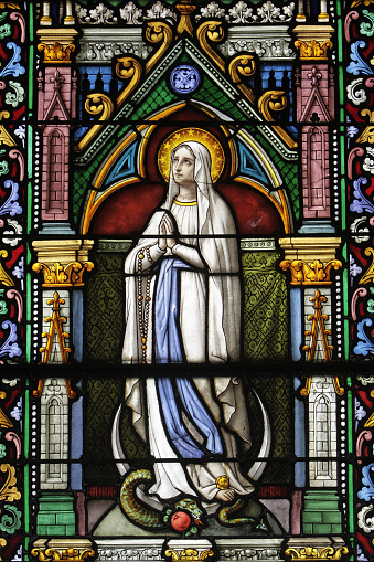 Europe. France. Seine-Maritime. Upper Normandy. Montiviliers. 04/10/2011. This colorful image depicts a stained glass window of the Virgin Mary praying. Montivilliers Abbey.