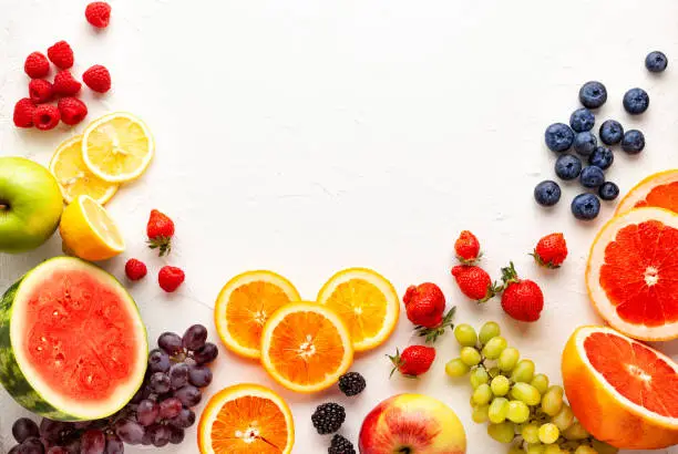 Photo of Assorted fresh fruits and berries on white background.