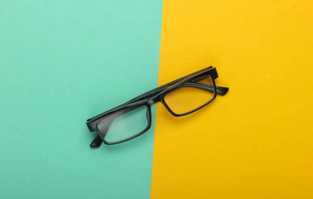 istock Classic eyeglasses on a yellow-blue background. Top view. Minimalism 1224208231