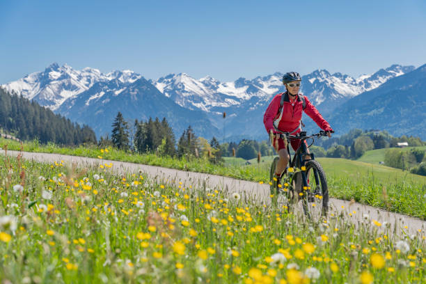 donna piuttosto anziana in mountain bike elettrica - allgau bavaria mountain horizon foto e immagini stock