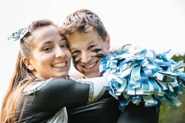 Cheerleader and American Football Player Couple in Love Happy smiling young couple - American Football Player and Cheerleader together. Embracing each other after the Football Game. American Football Lifestlye Shoot. football player girlfriend stock pictures, royalty-free photos & images