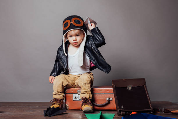 istock Boy in pilot's suit plays with paper planes 1224209987