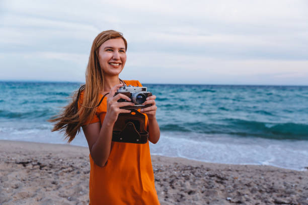 istock Woman with retro camera on the beach 1224210831