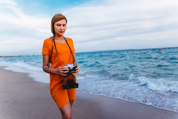 istock Woman with retro camera on the beach 1224211401