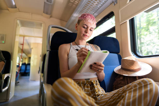 Girl writing her travel diary between the stations