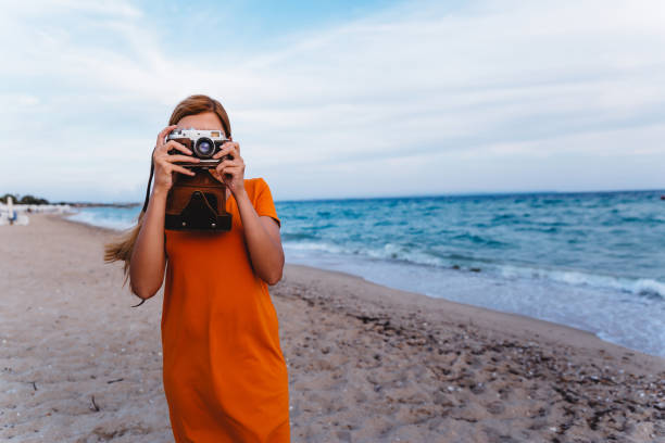 istock Woman with retro camera on the beach 1224212061