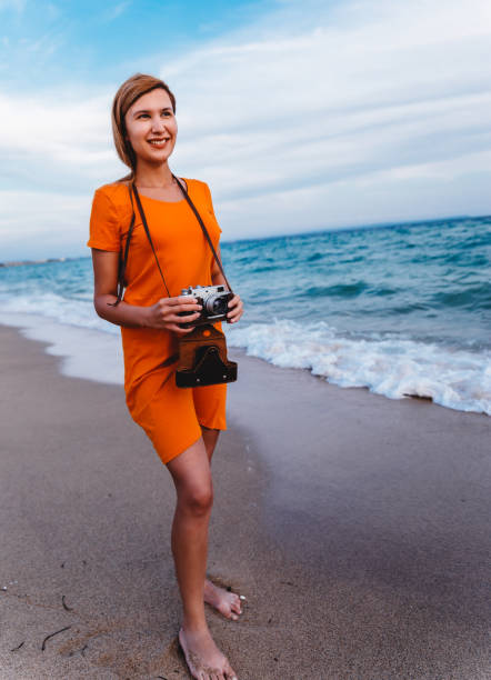 istock Woman with retro camera on the beach 1224212199