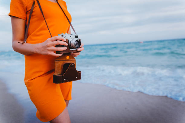 istock Woman with retro camera on the beach 1224212220
