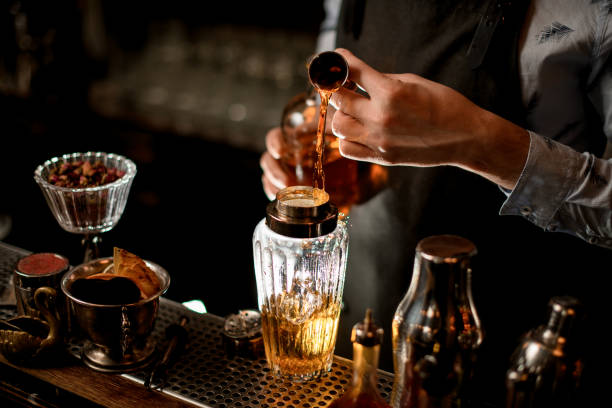 istock Close-up bartender using beaker professionally pours drink into glass shaker 1224212277