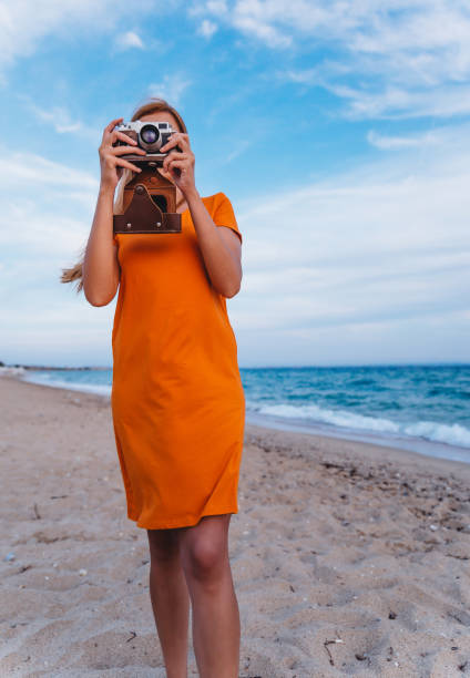 istock Woman with retro camera on the beach 1224212287