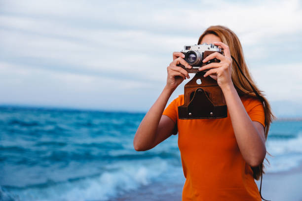 istock Woman with retro camera on the beach 1224212344