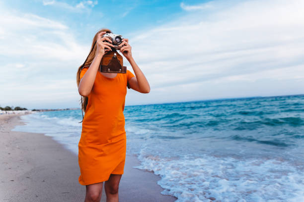 istock Woman with retro camera on the beach 1224212380