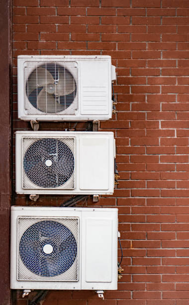 istock Three white air conditioners attached to a brick building 1224215399