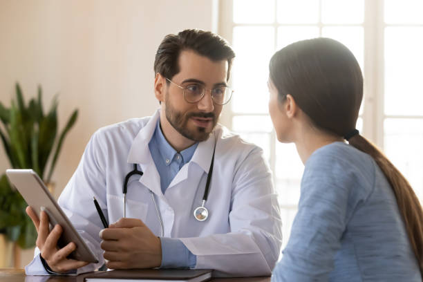 istock Young male doctor discuss results use tablet with patient 1224215467