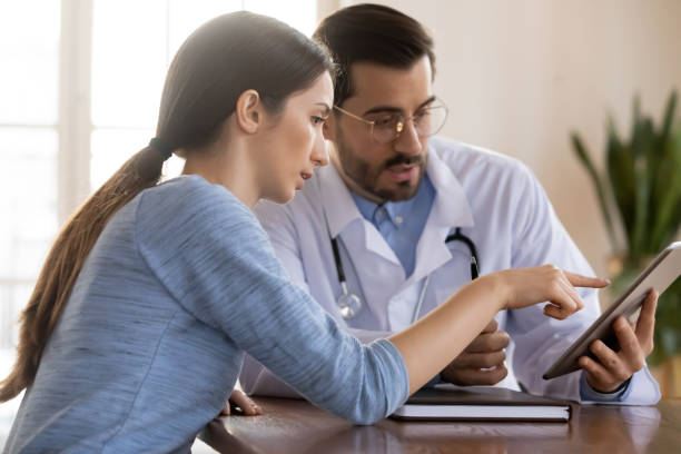 istock Male doctor discuss result on tablet with patient 1224215473