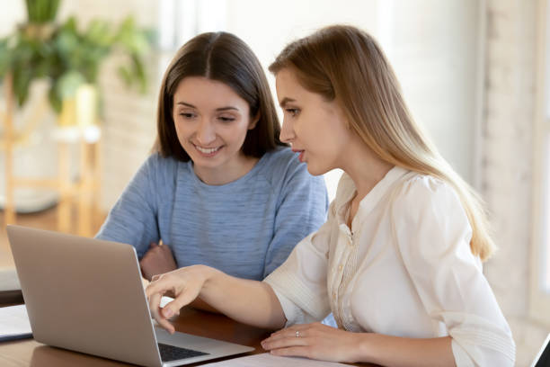 istock Smiling employees brainstorm work together on laptop 1224215576