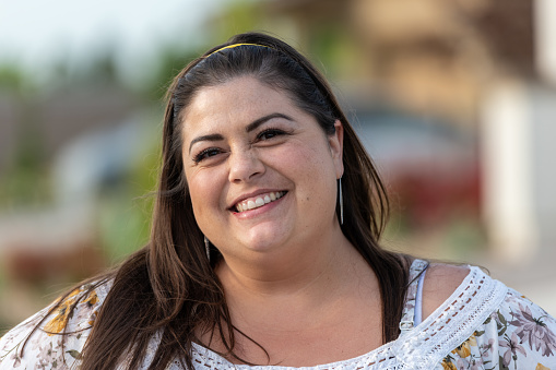 Smiling overweight mediterranen woman looking at the camera