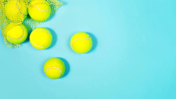 Photo of Tennis balls close up on blue hard tennis court.