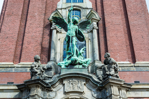 Sculpture of Angel killing a devil in front of Church of St. Michael, Hamburg, Germany. A landmark of the city and it is considered to be one of the finest Hanseatic Protestant baroque churches