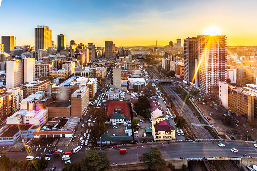 Johannesburg inner cityscape with the railway line and solar flare, Johannesburg is also known as Jozi, Jo'burg or eGoli, is the largest city in South Africa.