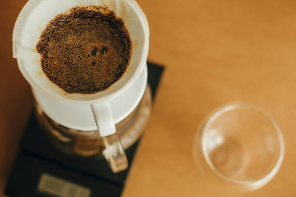 istock Brewing aromatic fresh coffee in paper filter closeup in pour over on scale. Alternative coffee brewing v60 closeup. Barista making filter coffee on brown background 1224220787