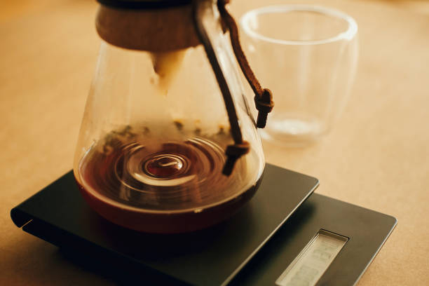 istock Drip coffee. Coffee drops closeup from filter in glass kettle on scale. Brewing aromatic fresh alternative coffee, v60 closeup. Barista making filter coffee 1224221546