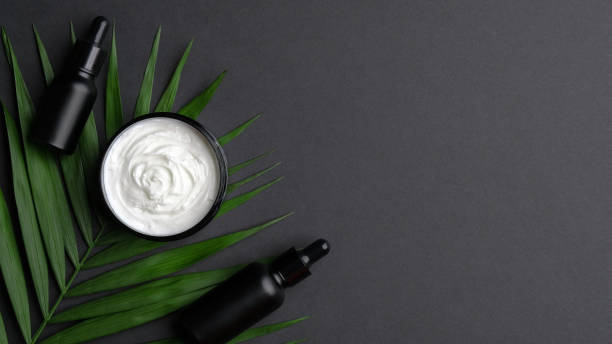 istock Natural cosmetics resting on a palm leave, isolated on black. 1224223576