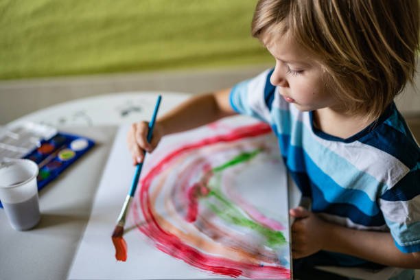 istock Little boy is painting rainbow 1224223632