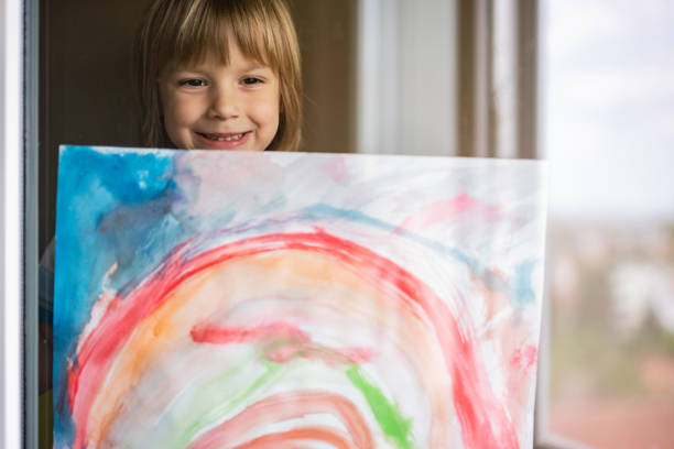 istock Boy sticking his drawing on home window during the coronavirus 1224223831