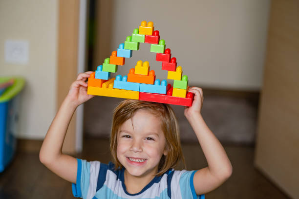 istock Little boy shows a plastic toy building 1224224502