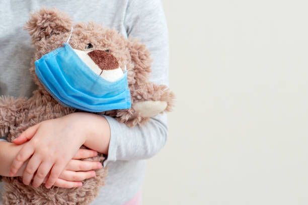 istock Toy bear with protective mask in child hands. 1224224908