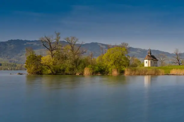 Photo of The historical St. Meinrad Chappel situated in an idyllic peninsula on the shores of the Upper Zurich Lake near Bollingen, st. Gallen, Switzerland