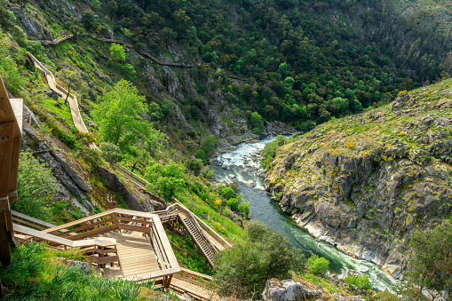 Beautiful landscape of the Paiva River, in Portugal, with a part of the river with its rapids and the Paiva walkways accompanying the slope on the left side of the river.