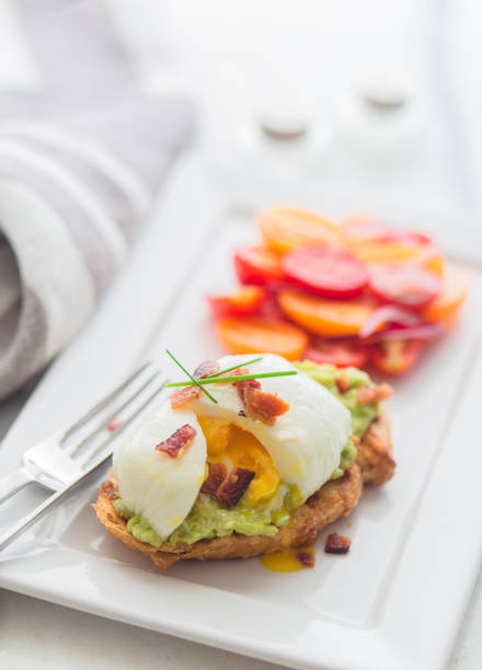 Avocado toast with poached egg and tomato salad  on a a marble top for brunch
