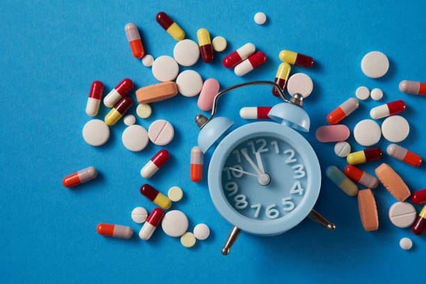 alarm clock and pills capsule and alarm clock on the blue background diet pills stock pictures, royalty-free photos & images